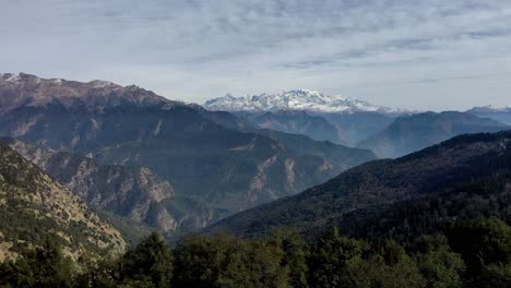 Aerial-one-view-center-moving-forward-showing-snow-covered-mountain-with-lots-of-trees