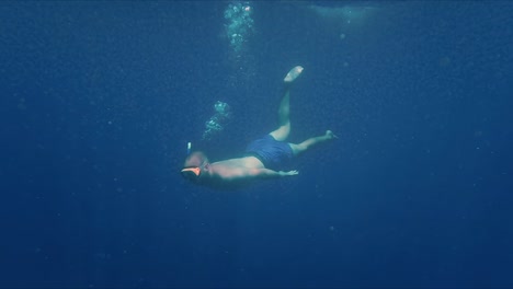 Buceador-Libre-Buceando-Bajo-El-Agua-Azul-Del-Océano.