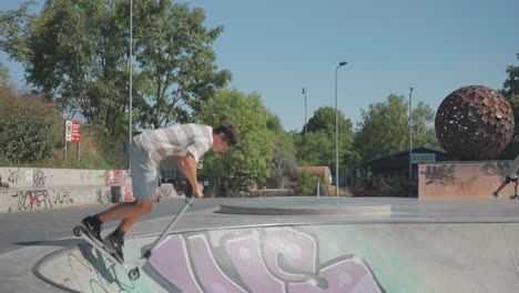 Mann-Fährt-Mit-Stunt-Scooter-Im-Skatepark-Bowl-Und-Führt-Slide-Tricks-Vor