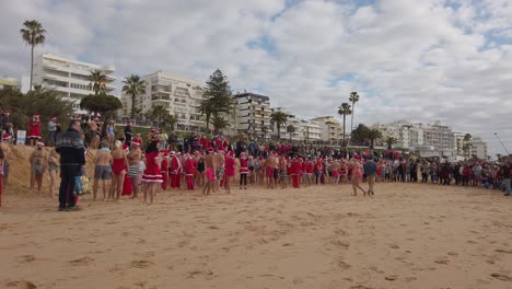 Personas-Vestidas-Como-Papá-Noel-Esperan-El-Inicio-Del-Tradicional-Baño-En-El-Mar.