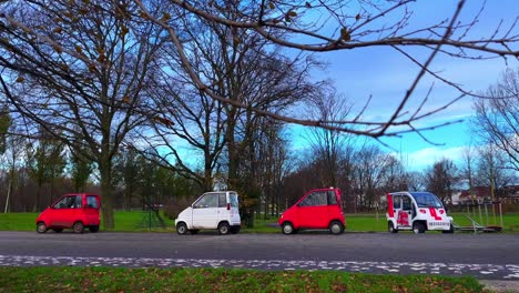 Cute-white-and-red-canta-cars-standing-in-row-at-parc-in-Amsterdam