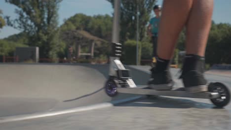 Man-activate-action-camera-video-recording-and-ride-into-skatepark-bowl