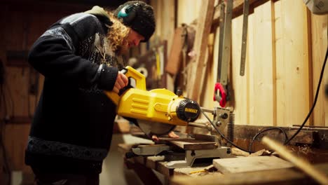 Man-At-His-Workshop-Cutting-Wood-Plank-With-Circular-Saw