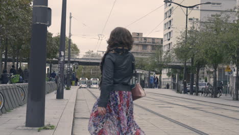 Slow-Motion-Shot-of-a-Woman-Crossing-Tramway-Rails-In-Vincennes,-France