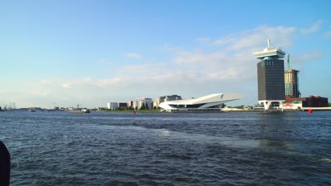 Tourist-Couple-Looking-Over-IJ-River-At-Eye-Film-Museum-In-Amsterdam,-Netherlands