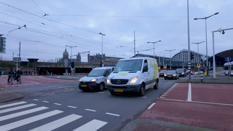 A-street-view-with-cars-and-a-pedestrian,-showcasing-typical-urban-life