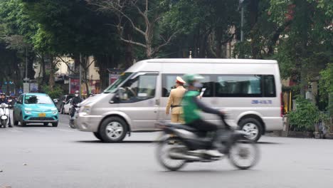 Police-officer-directing-traffic-stands-in-midst-of-bustling-intersections