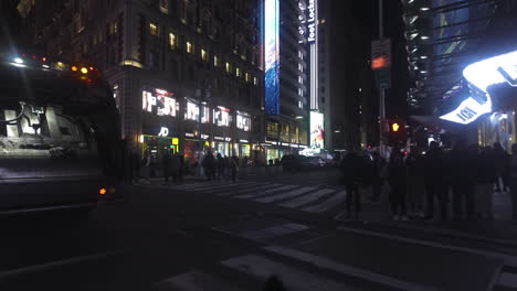 POV-shot-driving-past-crowds-of-people-on-the-nighttime-streets-of-New-York,-USA