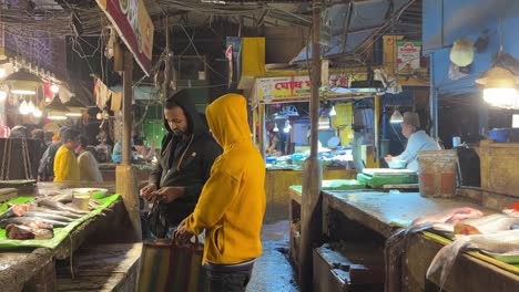 Static-shot-of-a-fish-market-with-people-buying-fish-during-night-in-Kolkata,-India