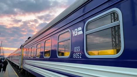 Ferrocarriles-Ucranianos-Tren-Ukrzaliznycia-Con-Un-Hermoso-Cielo-Rosado-Del-Amanecer-En-La-Estación-De-Tren-De-Chelm-En-Polonia,-Refugiados-Ucranianos-Esperando-Para-Abordar-El-Tren-Temprano-En-La-Mañana-A-Kyiv-Ucrania,-Toma-De-4k