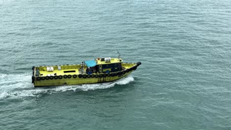 Top-down-view-of-a-moving-boat-navigating-on-the-sea-waters-in-Singapore