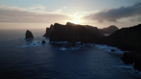 Drone-Volando-Sobre-El-Océano-Al-Amanecer-Viendo-La-Pintoresca-Costa-Del-Océano-Con-Acantilados-Bajo-Una-Vibrante-Puesta-De-Sol