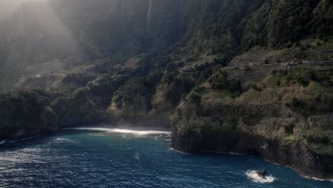 Luftdrohne-über-Dem-Meer-Geschossen,-Etwa-Ein-Lichtstrahl-Scheint-über-Dem-Ruhigen-Blauen-Meer-An-Grünen-Klippen-Auf-Madeira