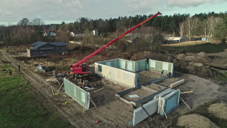 Baustelle-Mit-Arbeitern-Und-Kran-Beim-Zusammenbau-Von-Fertighausmodulen,-Luftaufnahme