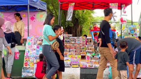 People-walk-in-front-of-market-stall