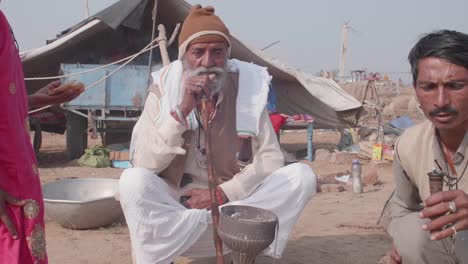 Seated-family-elder,-wisened-figure-smokes-from-his-traditional-Hookah