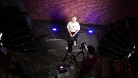 High-angle-view-of-guy-in-white-shirt-sit-in-podcast-recording-studio