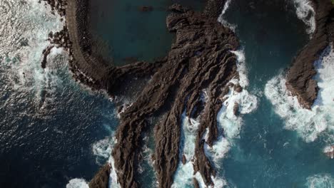 Aerial-top-shot-with-drone-of-a-serene-coastal-town-with-a-natural-lagoon-at-Seixal,-Madeira