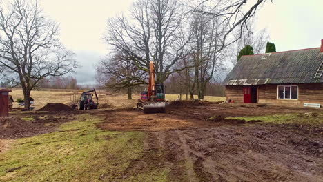 Ein-Kran-Und-Ein-Traktor-Sind-Damit-Beschäftigt,-Den-Sand-Im-Garten-Eines-Bauernhofs-Zu-Bewegen