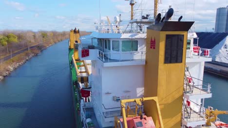 Drone-Sobrevolando-Un-Gran-Buque-De-Carga-Cisterna-En-El-Canal-De-Agua-De-Montreal,-Canadá