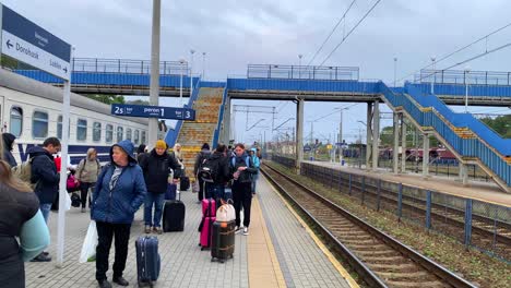 Ukrainian-refugees-waiting-for-a-train-to-arrive-at-the-Chelm-train-station-in-Poland,-people-fleeing-and-escaping-war,-4K-static-shot