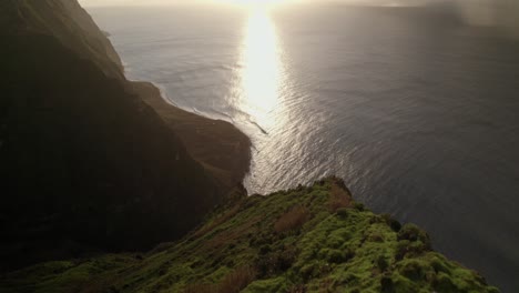 Toma-Aérea-De-Un-Dron-De-Una-Pintoresca-Vista-Costera-Del-Acantilado-Al-Atardecer-Con-Brillo-Oceánico