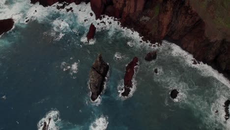 Toma-Aérea-Superior-Con-Un-Dron-En-Ponta-Do-Rosto-Sobre-El-Mar-Sobre-Acantilados-Y-Rocas-Escarpadas,-Olas-Y-Crestas-Montañosas.