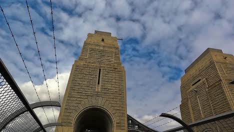 Sydney-Harbour-Bridge-Pylons,-Handheld-Shot-Looking-Up-At-The-Stone-Structures