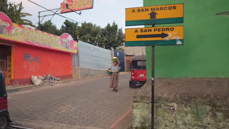 Taxis-Tuk-Tuk-En-La-Calle-Adoquinada-Y-Una-Mujer-Cargando-Cosas-Sobre-Su-Cabeza-Mientras-Camina