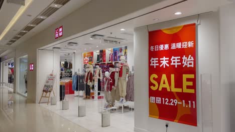 Toma-Cinematográfica-De-Paralaje-De-Un-Centro-Comercial-Con-Varias-Tiendas-De-Ropa-De-Uniqlo-En-Mira-Place,-Tsim-Sha-Tsui,-Hong-Kong.