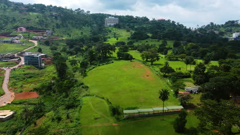 Vista-Aérea-Sobre-Un-Campo-De-Golf,-Hacia-El-Hotel-Mont-Fébé-En-Yaundé,-Camerún