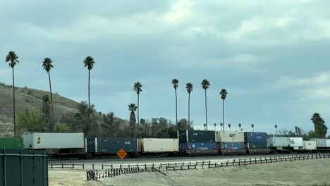 Shipping-Containers-On-A-Moving-Freight-Train-Servicing-Cities-Throughout-Southern-California,-USA