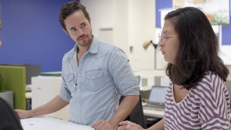 Colleagues-collaborating-over-documents-in-office