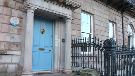 Facade-and-blue-door-with-columns-of-typical-stone-house-in-Dublin