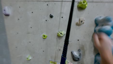 Un-Joven-Valiente-Escalando-Una-Pared-Vertical-En-El-Muro-De-Escalada