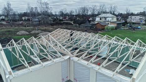 Rural-construction-site-with-workers-building-a-greenhouse-frame,-cloudy-day