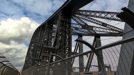 Handheld-View-Crossing-Sydney-Harbour-Bridge,-Walking-Along-The-Footpath