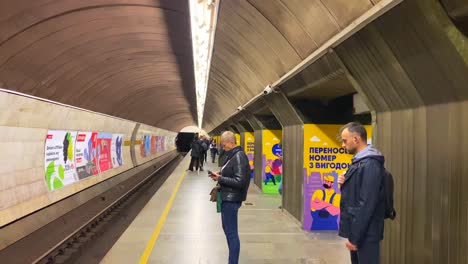 People-waiting-at-a-station-to-take-the-underground-subway-metro-tube-in-Kyiv-Ukraine,-quick-transportation-around-a-city,-4K-shot