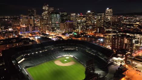 Luftdrohnenüberflug-Des-Coors-Field-Baseballstadions-Bei-Nacht-Mit-Der-Skyline-Von-Denver,-Colorado-Im-Hintergrund