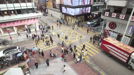 Foto-Superior-De-Personas-Cruzando-La-Calle-A-Través-Del-Paso-De-Cebra-En-Una-Calle-Muy-Transitada-En-Carnarvon-Road,-Tsim-Sha-Tsui,-Hong-Kong.