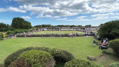 Crowds-gathered-at-a-outdoor-summer-crown-green-bowling-match,-competition