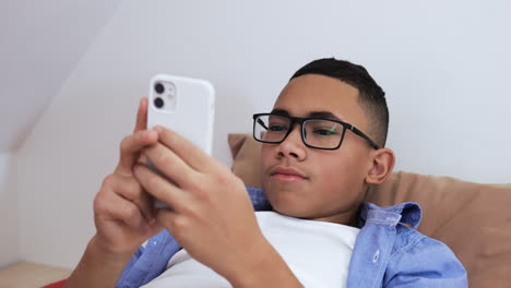 Young-boy-using-phone-on-bed