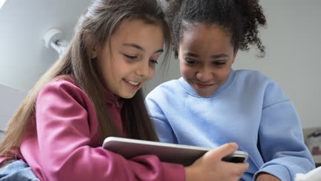 Girls-using-tablet-in-the-bedroom