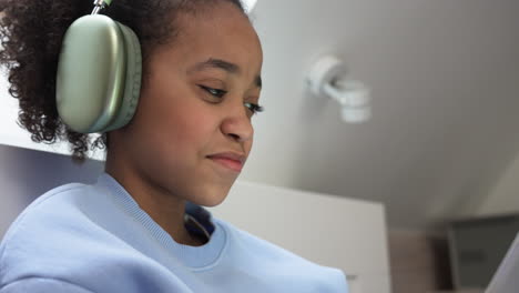 Young-girl-using-headphones-on-bed