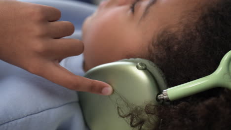 Young-girl-using-headphones-on-bed