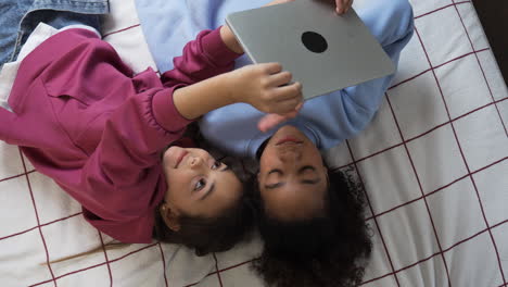 Girls-using-tablet-in-the-bedroom