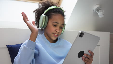 Young-girl-using-headphones-on-bed