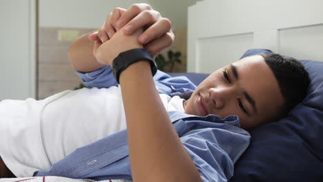 Boy-laying-on-his-bed,-watching-his-watch