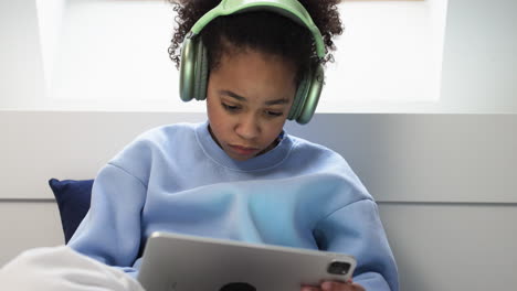 Young-girl-using-headphones-on-bed