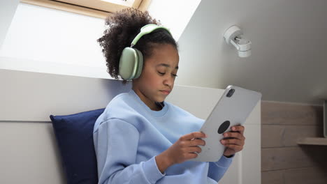 Young-girl-using-headphones-on-bed